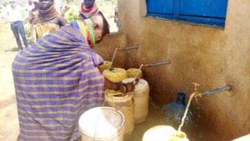 A woman fetching water from a water kiosk. (KDRDIP project ), PHOTO COURTESY DEBRA LOCHA